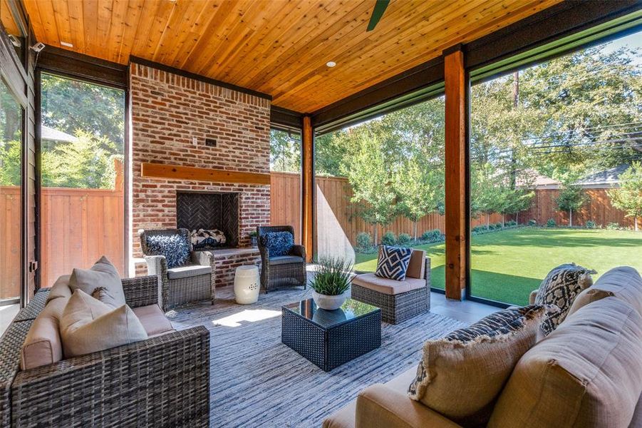 Sunroom / solarium with wooden ceiling and an outdoor brick fireplace