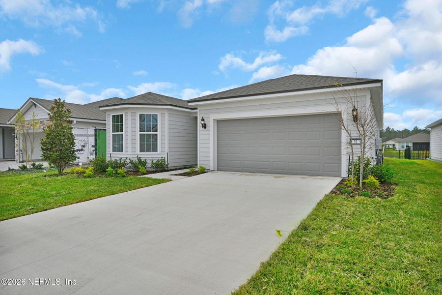 Front exterior of a new home in Summer Bay at Grand Oaks, St. Augustine, FL, highlighting curb appeal (Image 22).