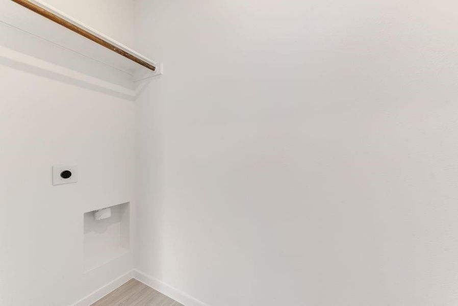 Clothes washing area with light wood-type flooring, laundry area, electric dryer hookup, and baseboards