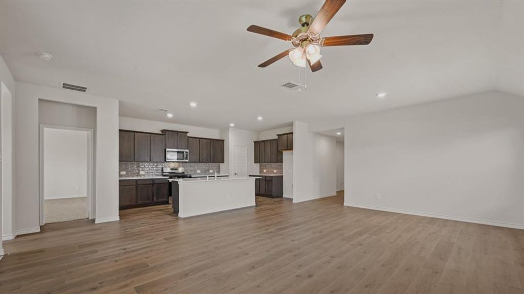 Open-concept living space featuring wood-finish flooring, recessed lighting, and a ceiling fan Open-concept living space featuring wood-finish flooring, recessed lighting, and a ceiling fan