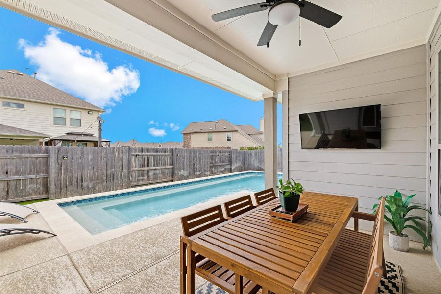 The covered back patio overlooks the pool and creates an easy spot to enjoy the yard from morning to evening