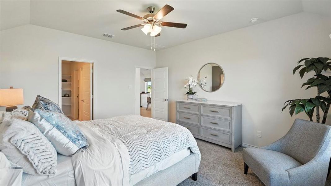 Bedroom featuring vaulted ceiling, carpet floors, ceiling fan, and connected bathroom