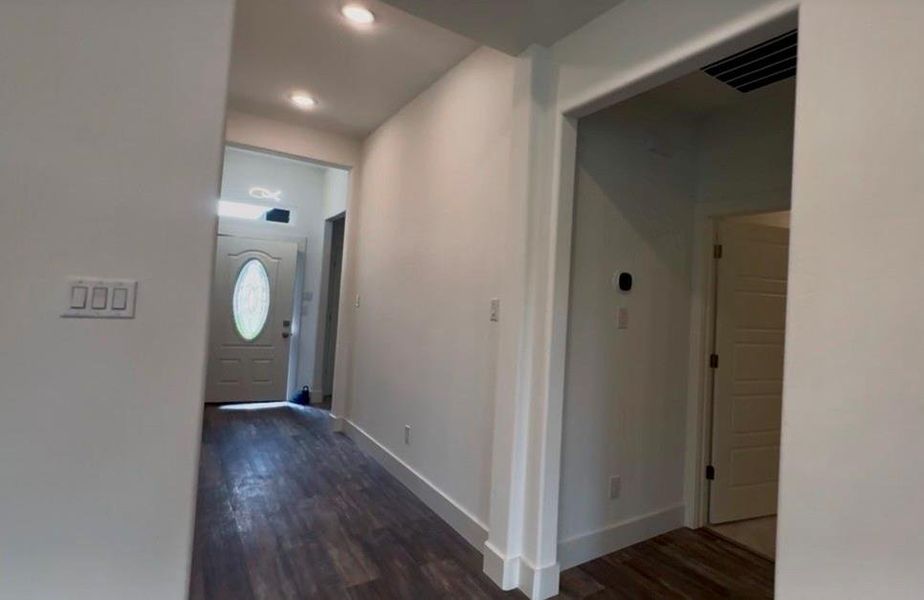 Entryway featuring wood-finish flooring, recessed lighting, white trim, and a front door with an oval glass insert