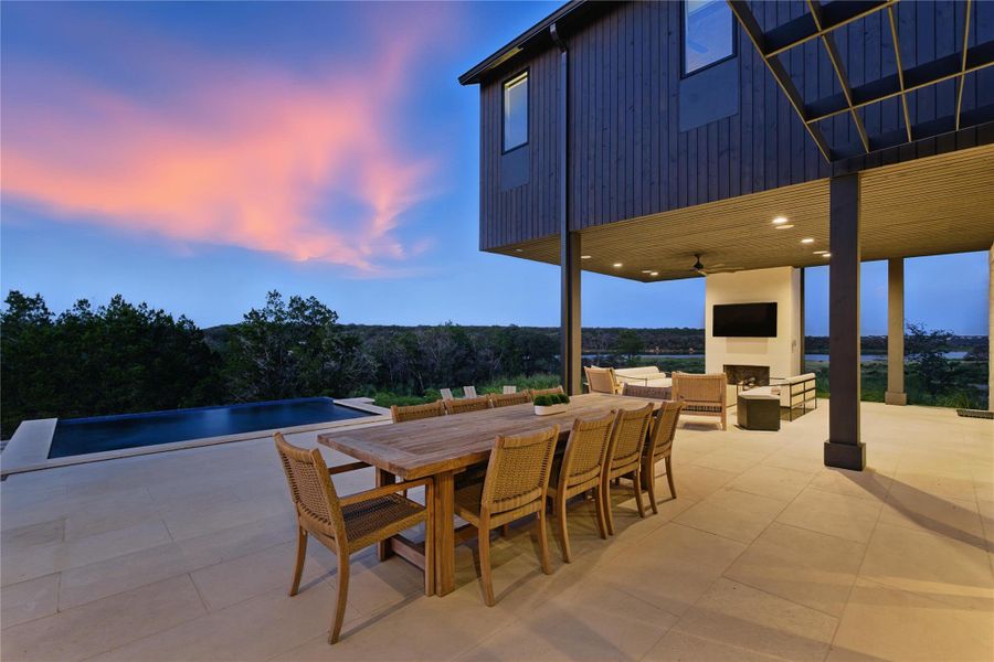 View of patio / terrace with outdoor dining area, an infinity pool, and an outdoor living space with a fireplace