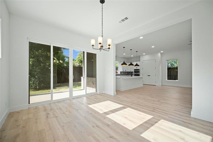 Unfurnished living room featuring a chandelier, light wood-type flooring, and recessed lighting