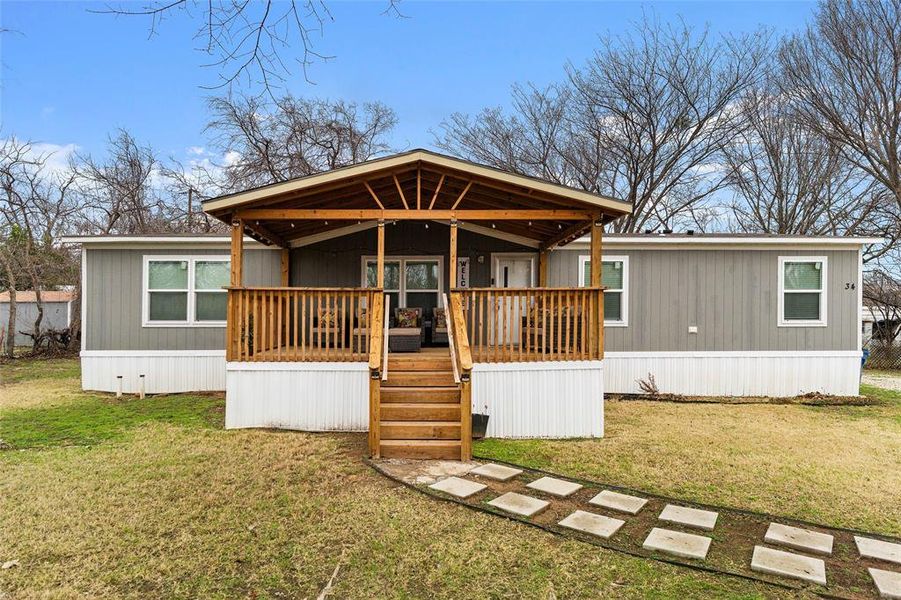 Back of property with covered porch and a lawn