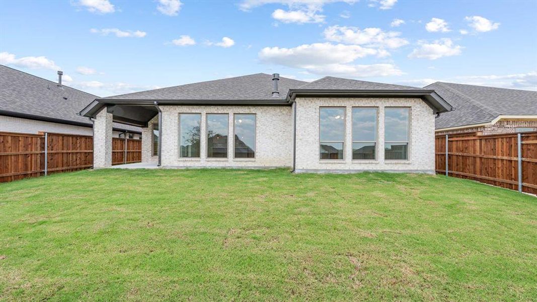 Back of house featuring a lawn