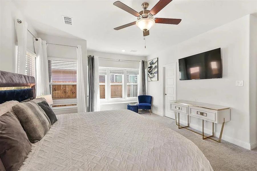 Carpeted bedroom featuring ceiling fan