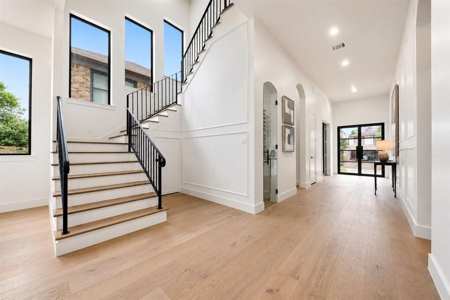 Grand stairway landing filled with light, luggage storage closet under the stairway and 12 foot ceilings. Landing has views into the wine room