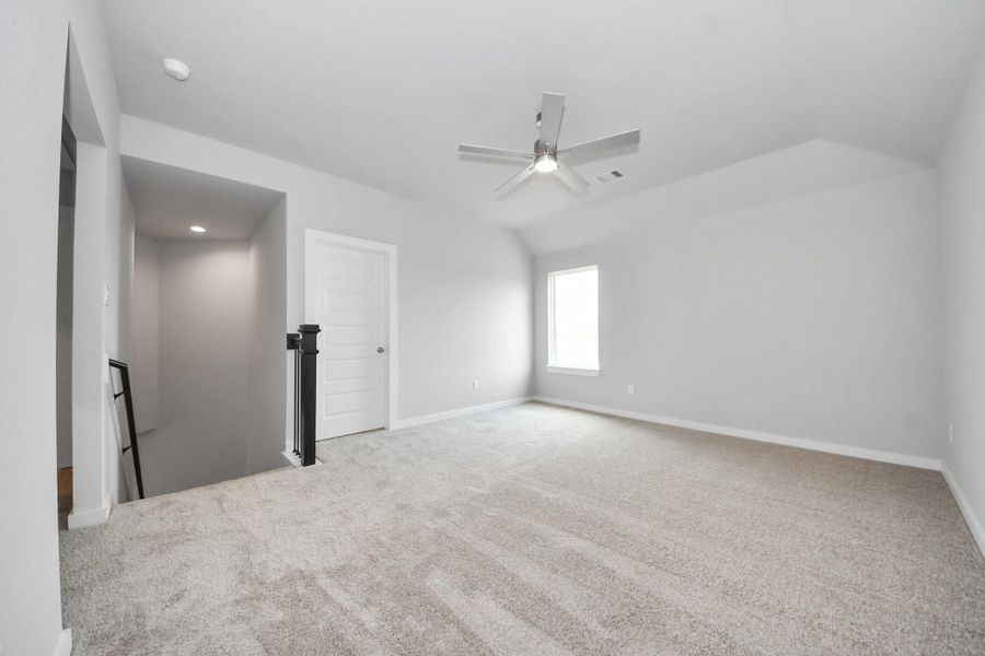 Ascend to relaxation in this fantastic game room! Ideal for both casual gatherings and adult gaming, it boasts plush carpet, lofty ceilings, custom paint, and ample windows for abundant natural light. Sample photo of completed home with similar floor plan. Actual colors and selections may vary.