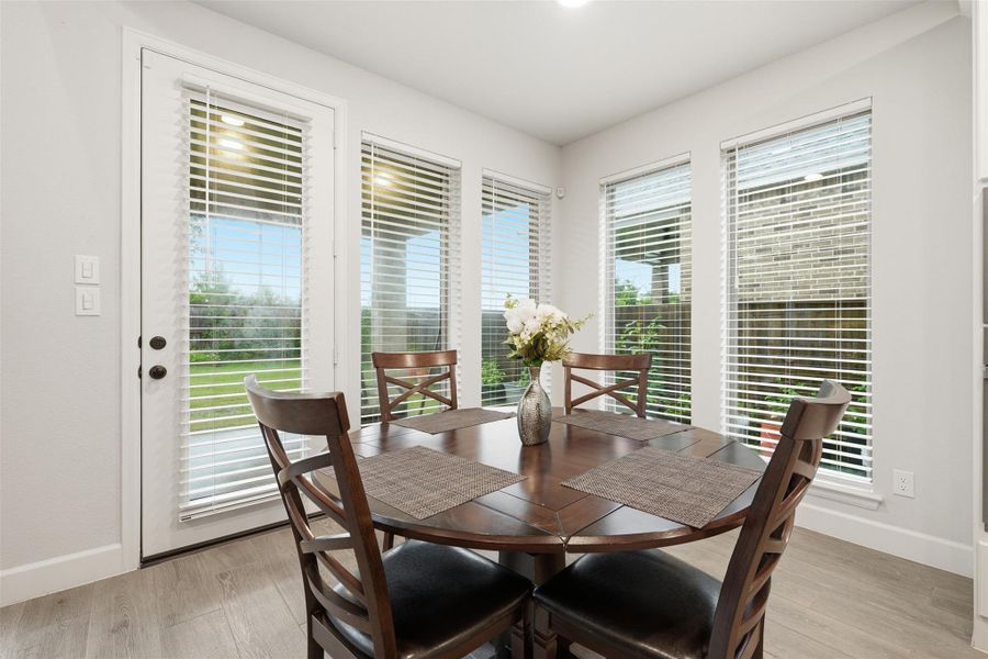 Bright breakfast nook with large windows and blinds, featuring a view of the backyard. Bright breakfast nook with large windows and blinds, featuring a view of the backyard.