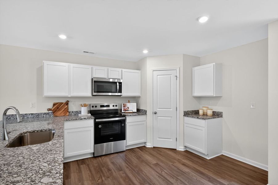 A kitchen with white cabinets.