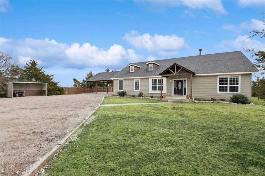 View of front facade with a front lawn and a carport