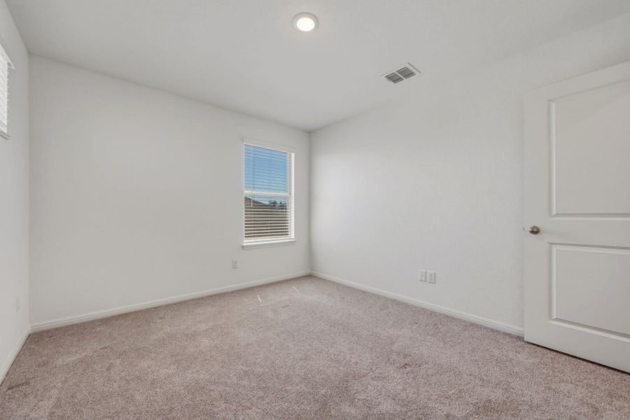 Spare room featuring light colored carpet and baseboards