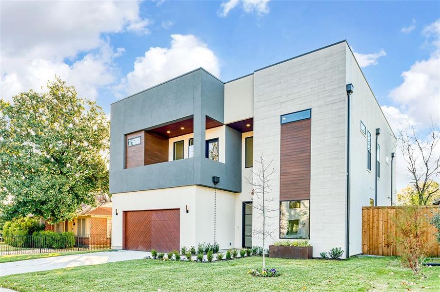 Modern home with a front yard and a garage