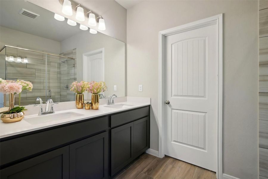 Look at the spacious double sink counters with a contrast to a gorgeous dark cabinetry.