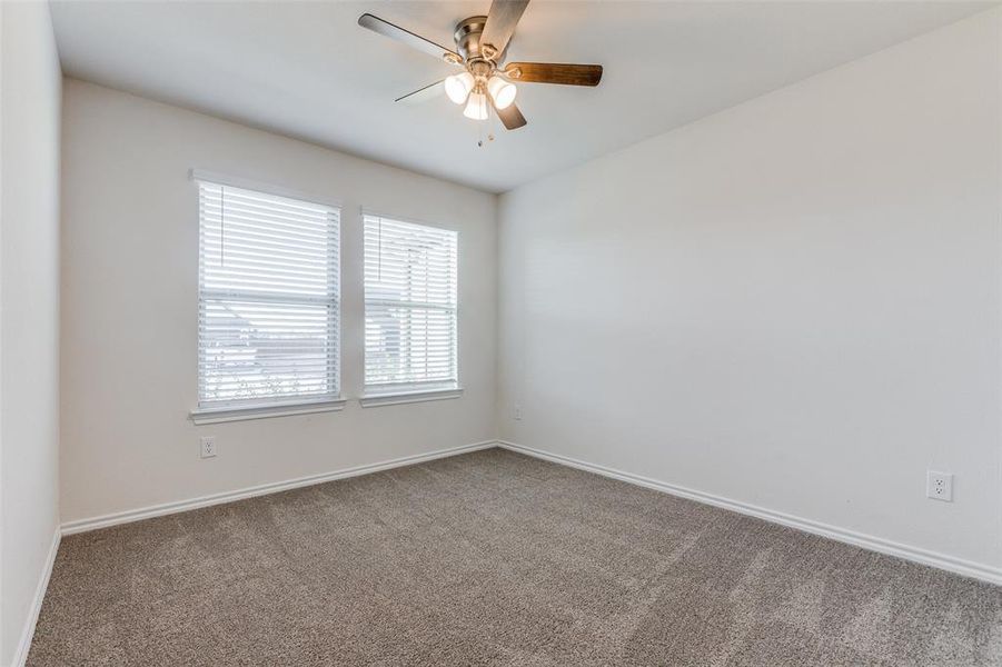 Empty room featuring carpet flooring and ceiling fan