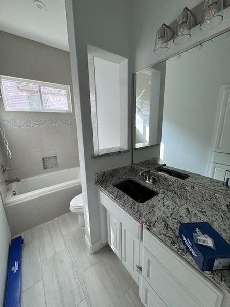Full bath featuring double vanity and toilet