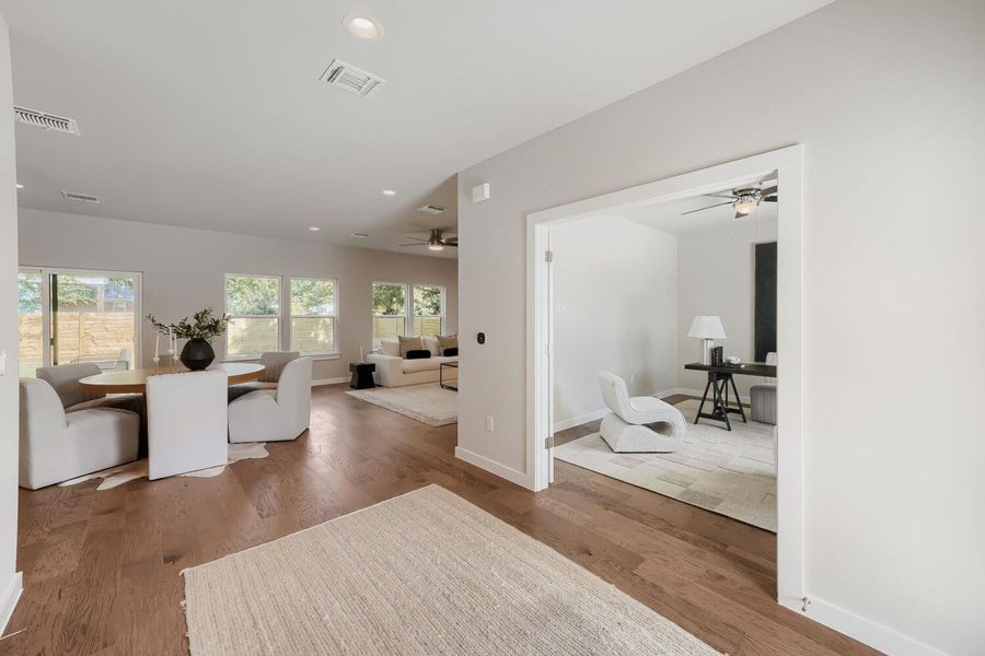 Rich hardwood floors unite an open concept living area, bathed in natural light, with a dedicated home office. Rich hardwood floors unite an open concept living area, bathed in natural light, with a dedicated home office.