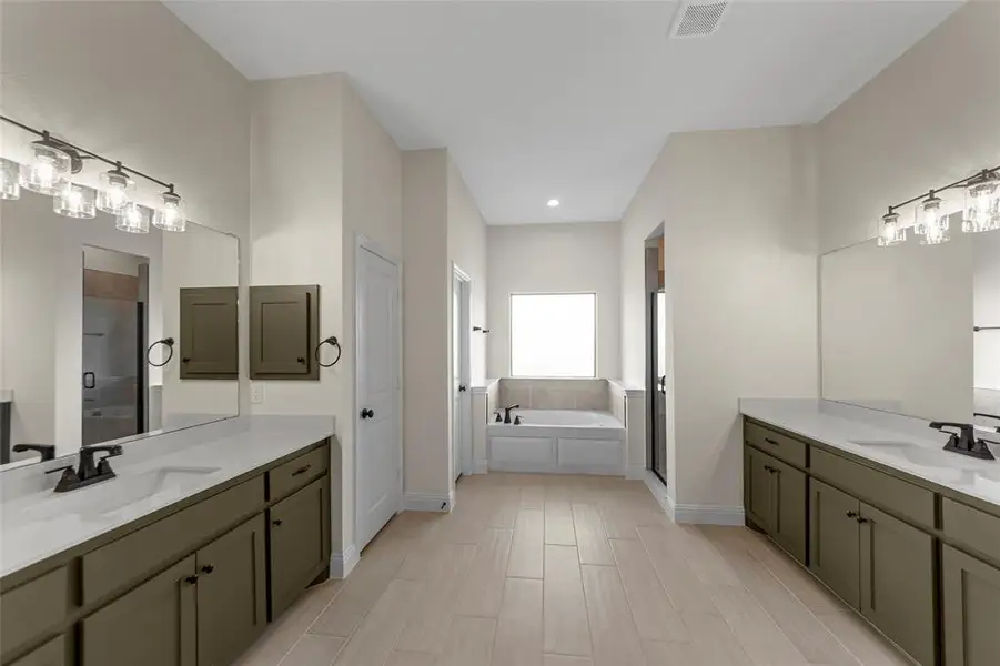 Full bathroom with two vanities, a shower stall, a bath, and wood tiled floors Full bathroom with two vanities, a shower stall, a bath, and wood tiled floors