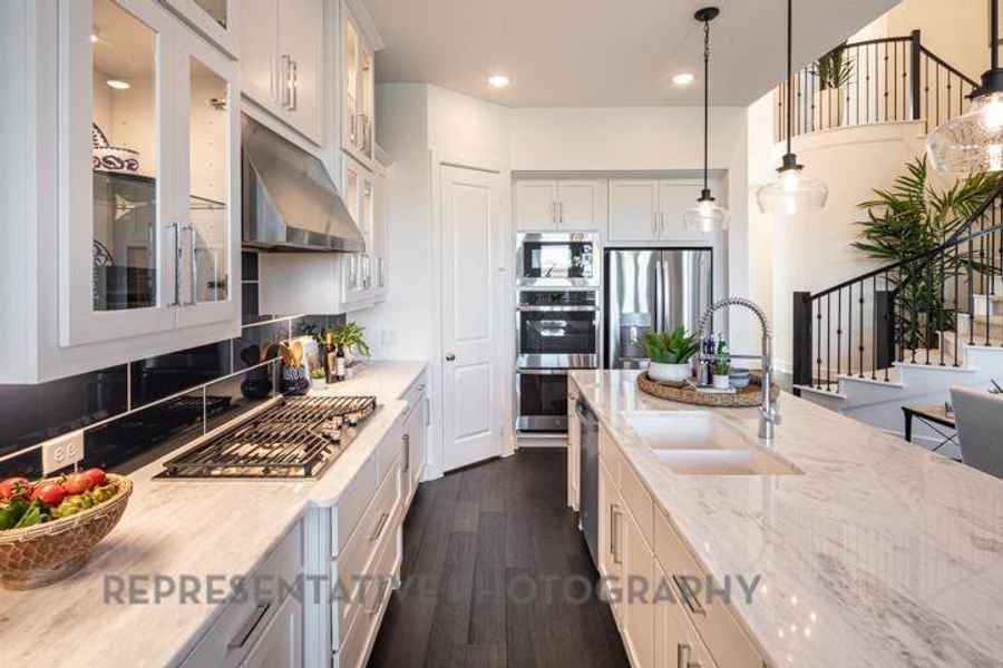 Kitchen featuring light stone counters, recessed lighting, pendant lighting, dark wood-type flooring, and stainless steel appliances Kitchen featuring light stone counters, recessed lighting, pendant lighting, dark wood-type flooring, and stainless steel appliances