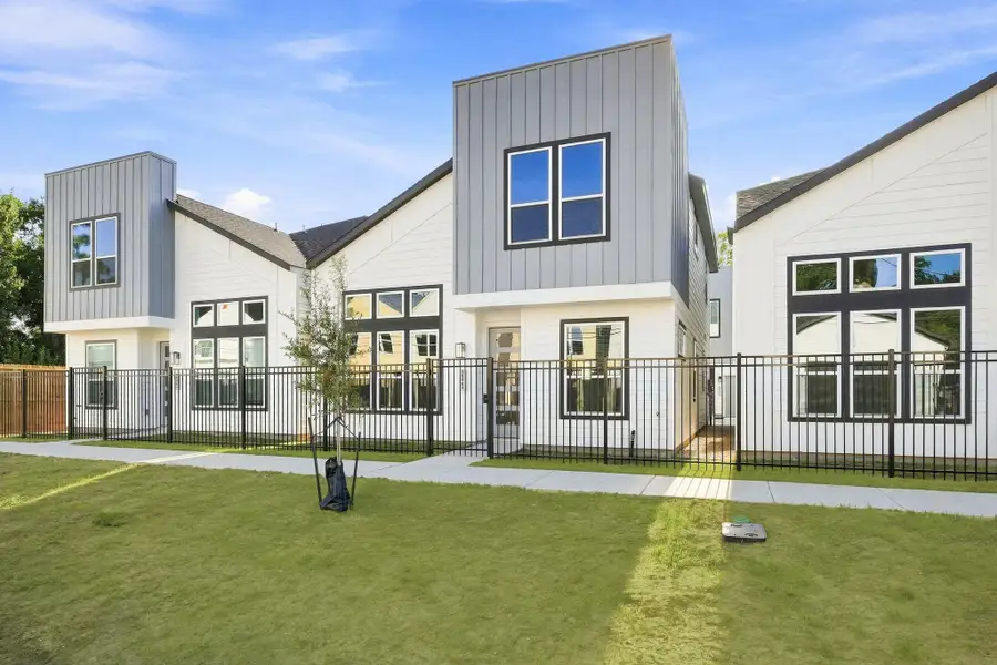 Street-level view showcasing the modern architecture, fenced front yards, sidewalks, and cohesive contemporary design throughout the community. Street-level view showcasing the modern architecture, fenced front yards, sidewalks, and cohesive contemporary design throughout the community.