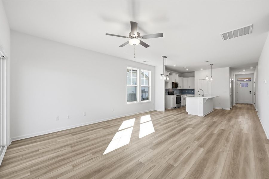 Unfurnished living room with a ceiling fan, light wood finished floors, and recessed lighting Unfurnished living room with a ceiling fan, light wood finished floors, and recessed lighting