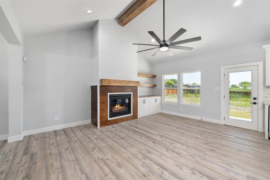 Unfurnished living room with recessed lighting, a glass covered fireplace, light wood-style flooring, and a ceiling fan