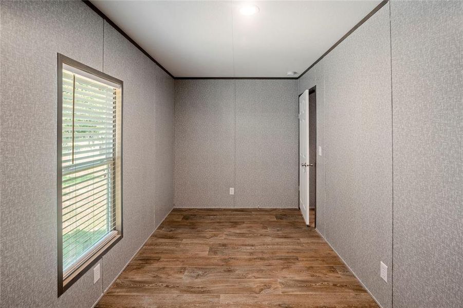 Empty room featuring wood finished floors and a textured wall