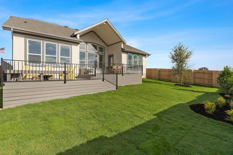 Back of house featuring stucco siding, roof with shingles, and a fenced backyard