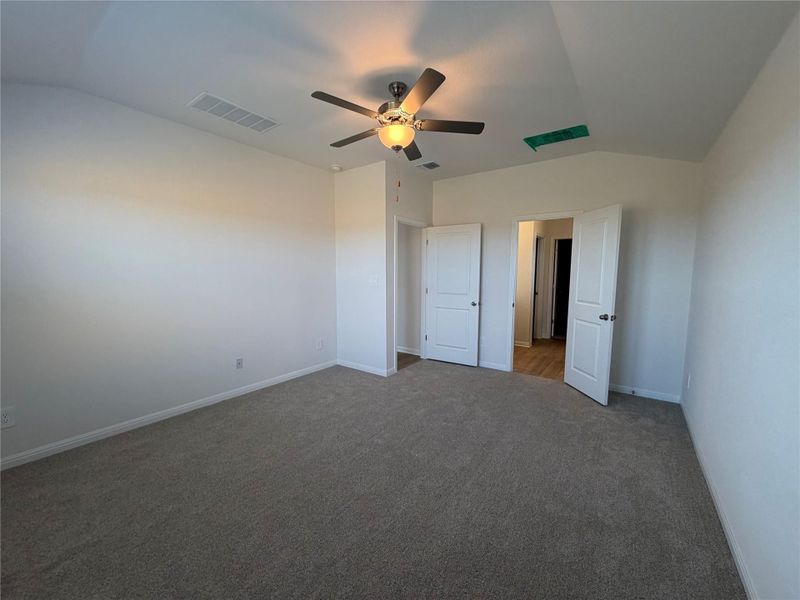 Unfurnished bedroom with lofted ceiling, ceiling fan, and carpet floors