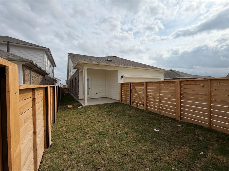 Fenced backyard with a patio area