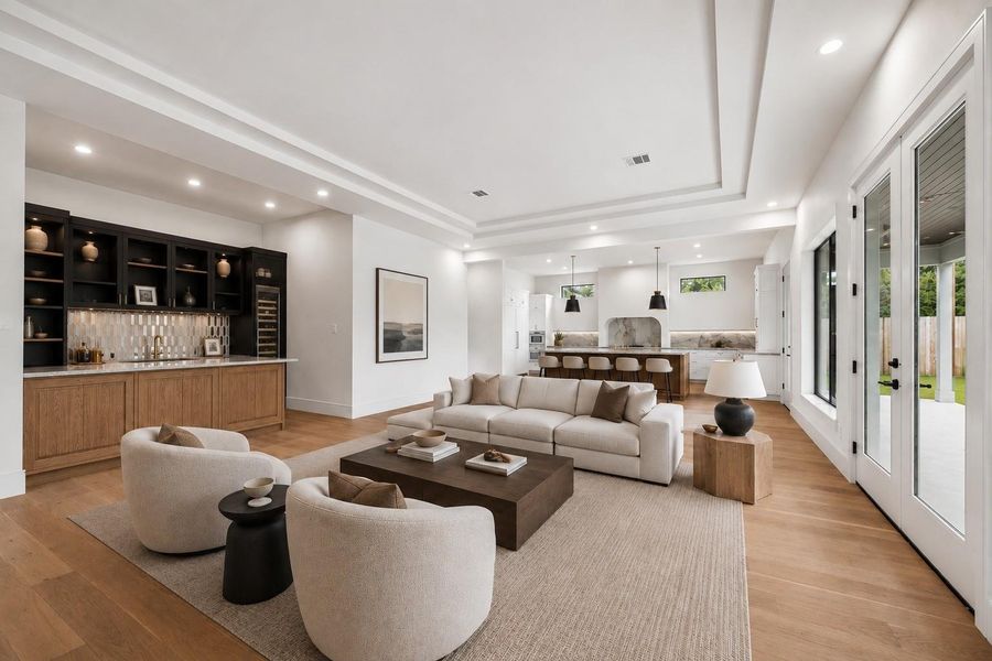 Designed for gathering, the open living room flows effortlessly between the chef’s kitchen, wet bar, and covered outdoor living area. Soaring tray ceilings, expansive windows, and walls of glass create a bright, connected space that is equally suited for quiet evenings or entertaining a crowd. **Virtually staged**