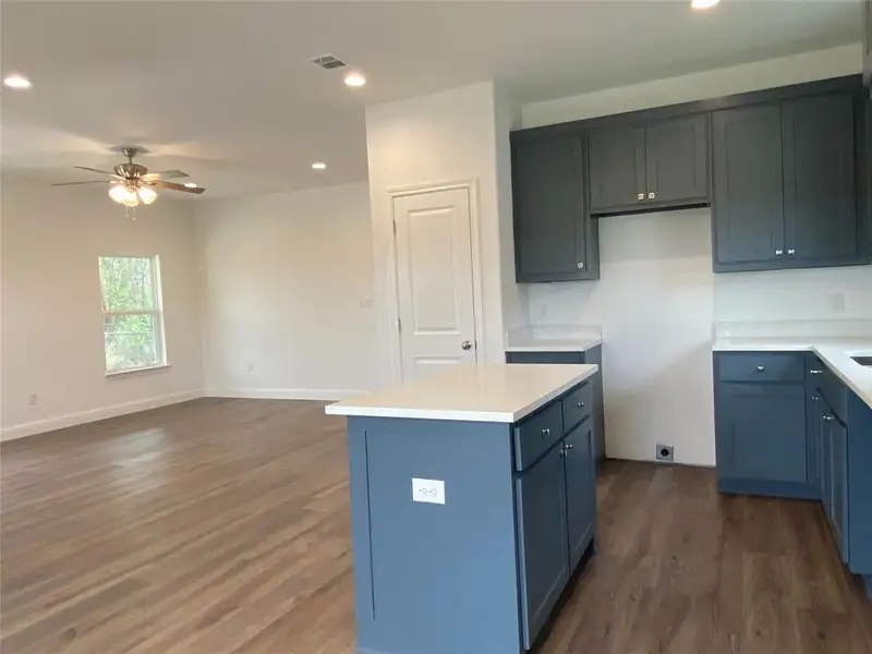 Kitchen featuring recessed lighting, dark wood-style floors, a kitchen island, cabinetry, and a ceiling fan Kitchen featuring recessed lighting, dark wood-style floors, a kitchen island, cabinetry, and a ceiling fan