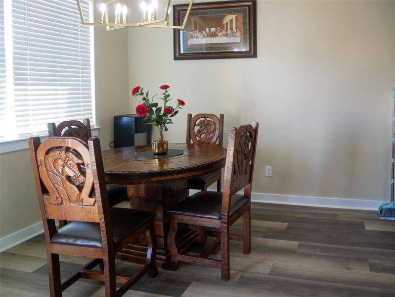 Dining room with dark wood finished floors and a chandelier