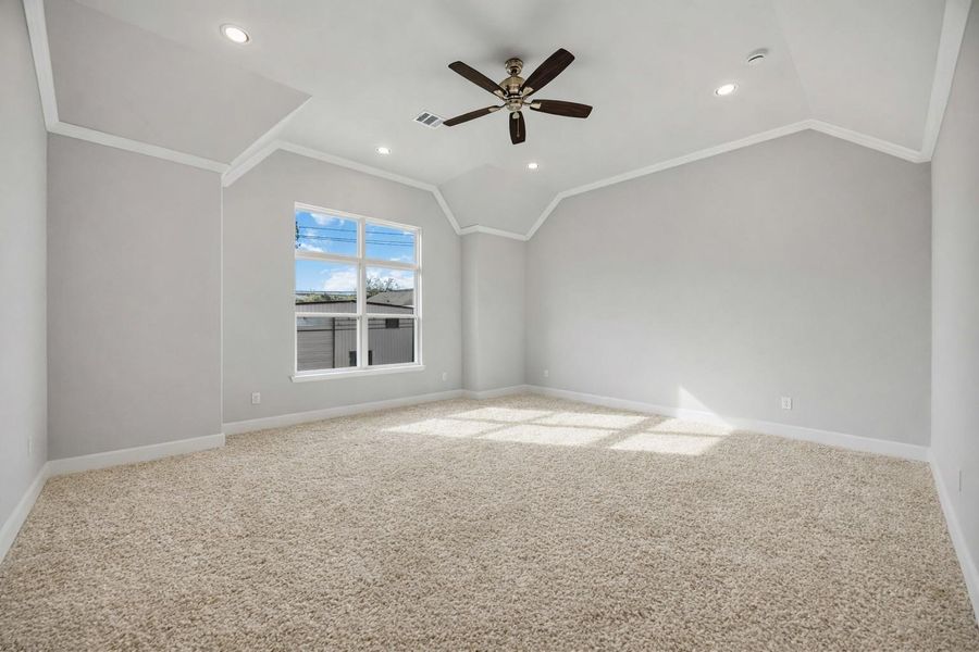 Step into a primary suite that lives like a luxury retreat—soaring ceilings, soft carpet underfoot, and a wall of windows bringing the outside in.