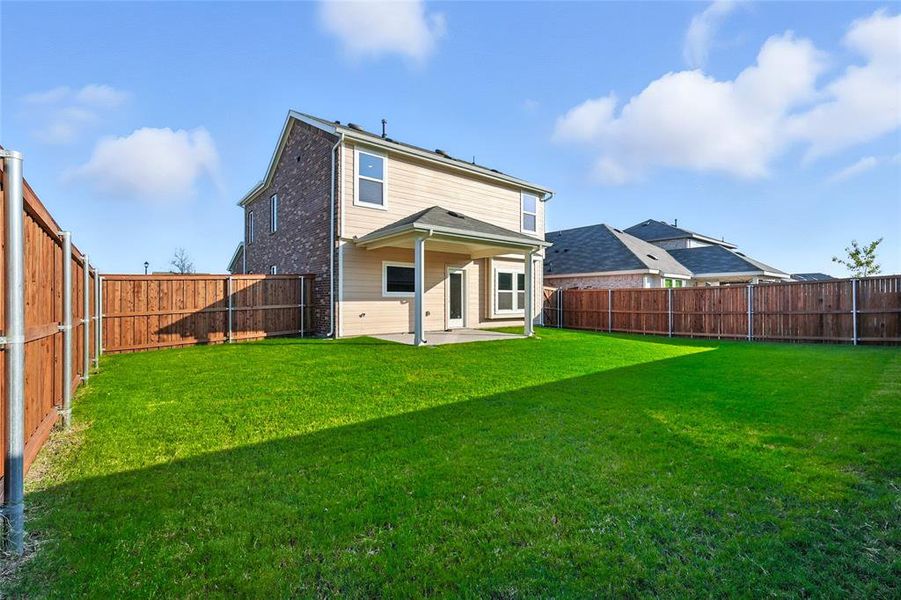 Back of house featuring a patio area, a fenced backyard, and brick siding Back of house featuring a patio area, a fenced backyard, and brick siding