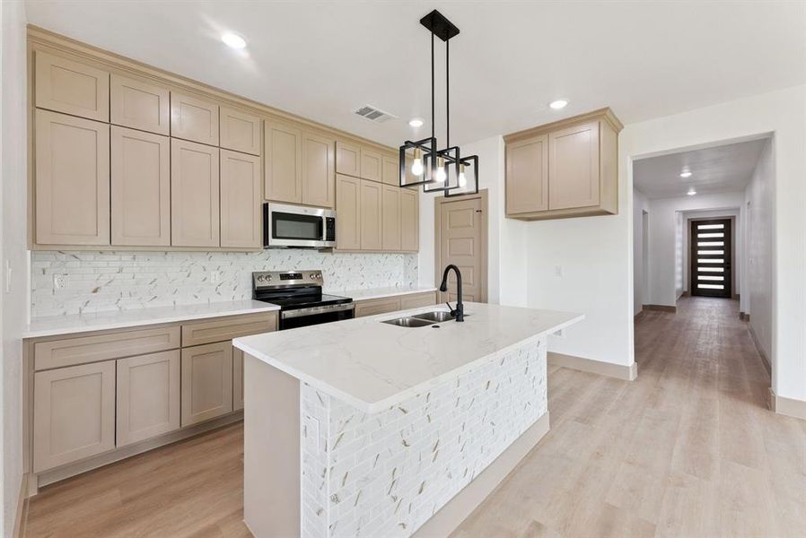 Kitchen with decorative backsplash, light stone counters, stainless steel appliances, light wood-style flooring, and recessed lighting Kitchen with decorative backsplash, light stone counters, stainless steel appliances, light wood-style flooring, and recessed lighting