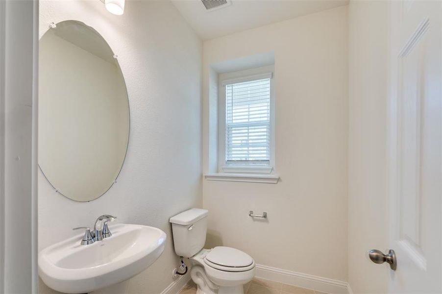 Half bath featuring baseboards and tile patterned flooring