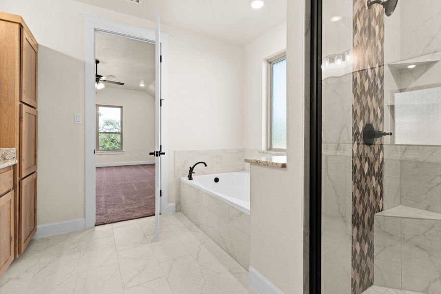 Full bath with a garden tub, a marble finish shower, vanity, plenty of natural light, and recessed lighting Full bath with a garden tub, a marble finish shower, vanity, plenty of natural light, and recessed lighting
