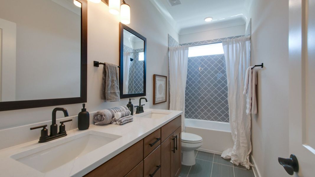 Secondary Bathroom with shower, toilet, and dual-vanity with natural light Secondary Bathroom with shower, toilet, and dual-vanity with natural light