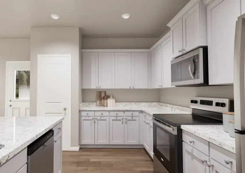 A modern kitchen with white cabinets, granite countertops, and a stainless steel fridge.