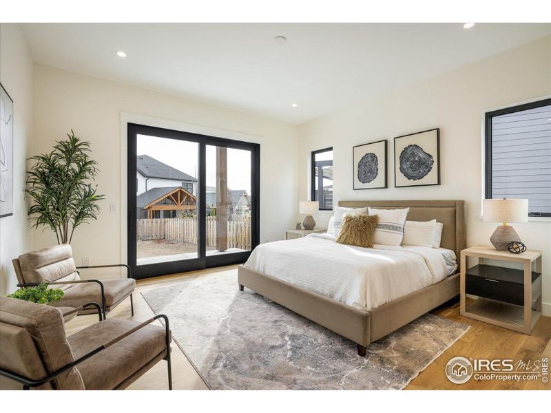 The Main Floor Primary Suite includes easy access to the pergola-covered back patio and ample room for seating