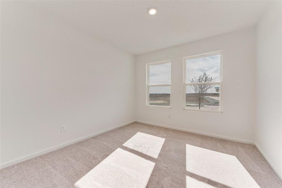 Empty room featuring light colored carpet