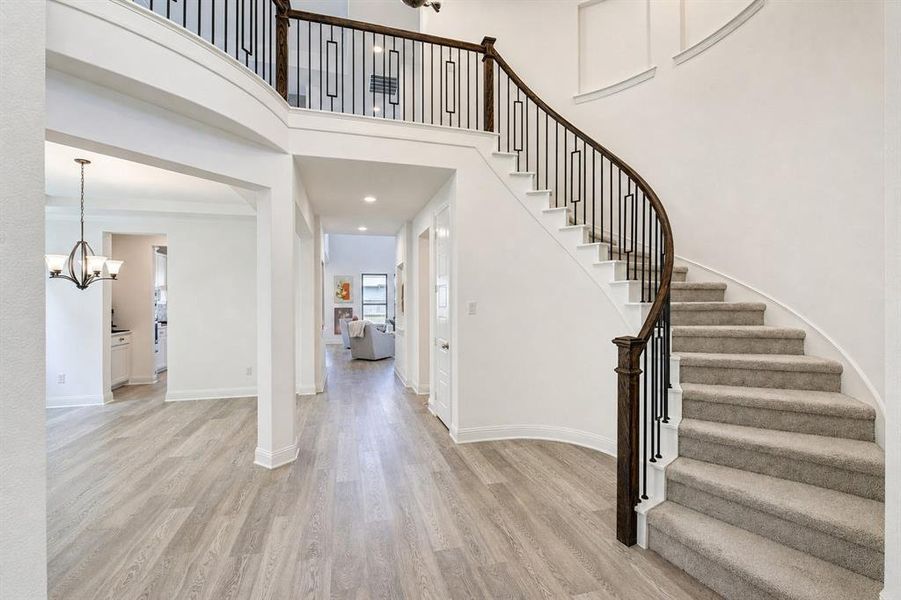 A dramatic two-story entry with a curved staircase welcomes you inside.