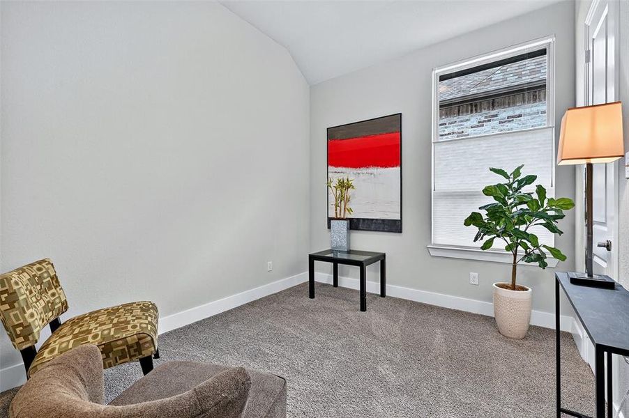 Living area with vaulted ceiling and carpet flooring Living area with vaulted ceiling and carpet flooring