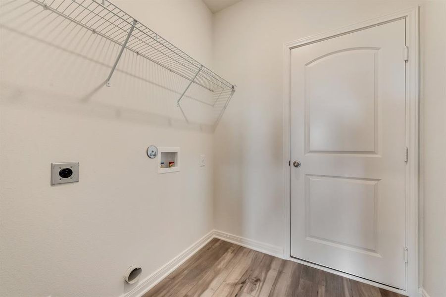 Clothes washing area featuring gas dryer hookup, hookup for an electric dryer, wood-type flooring, and washer hookup