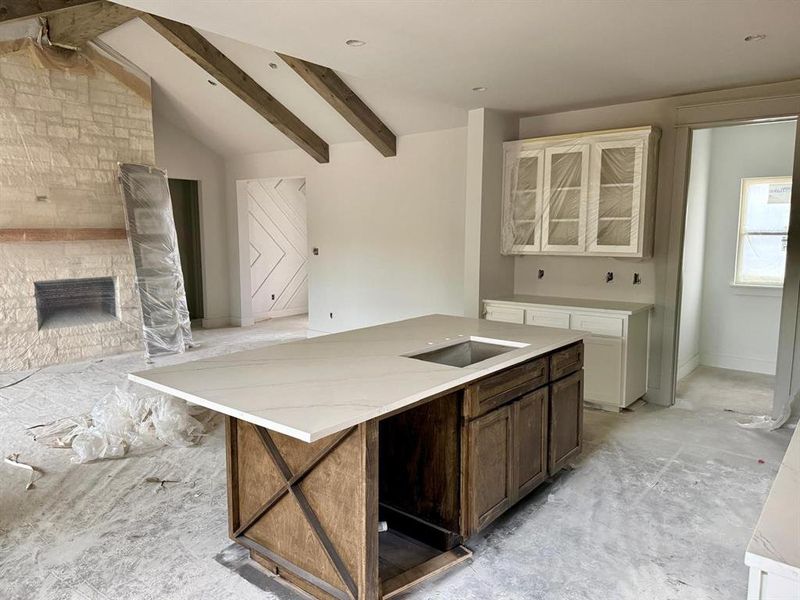Kitchen with an island with sink, glass insert cabinets, white cabinets, a fireplace, and dark brown cabinets Kitchen with an island with sink, glass insert cabinets, white cabinets, a fireplace, and dark brown cabinets
