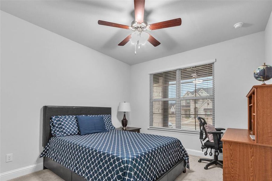 Bedroom featuring light carpet, ceiling fan, and baseboards