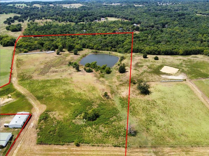 Aerial view of sparsely populated area with a nearby body of water and property boundaries highlighted Aerial view of sparsely populated area with a nearby body of water and property boundaries highlighted